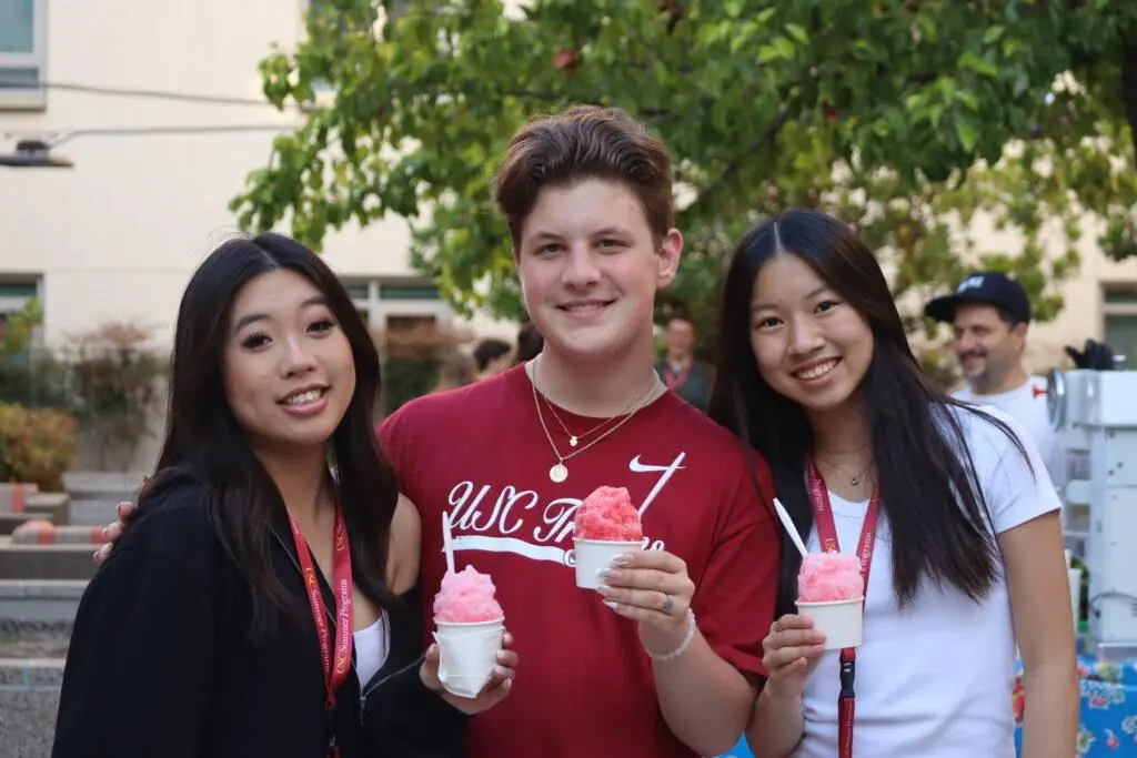 Three students in USC Summer Programs hold pink snowcones and smile at the camera. Here are some benefits of non-credit summer programs.