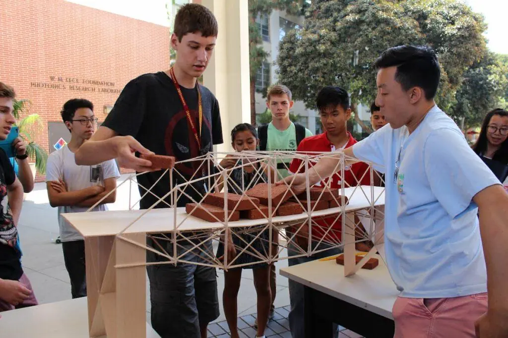 Students in USC's "Discover Engineering" pre-college program test a bridge they built.