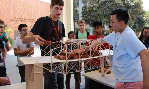 Students in USC's "Discover Engineering" pre-college program test a bridge they built.