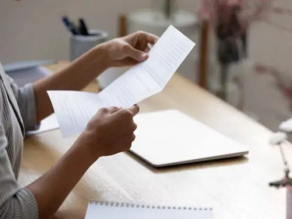 Woman's hands holding up a typed letter of recommendation for college.