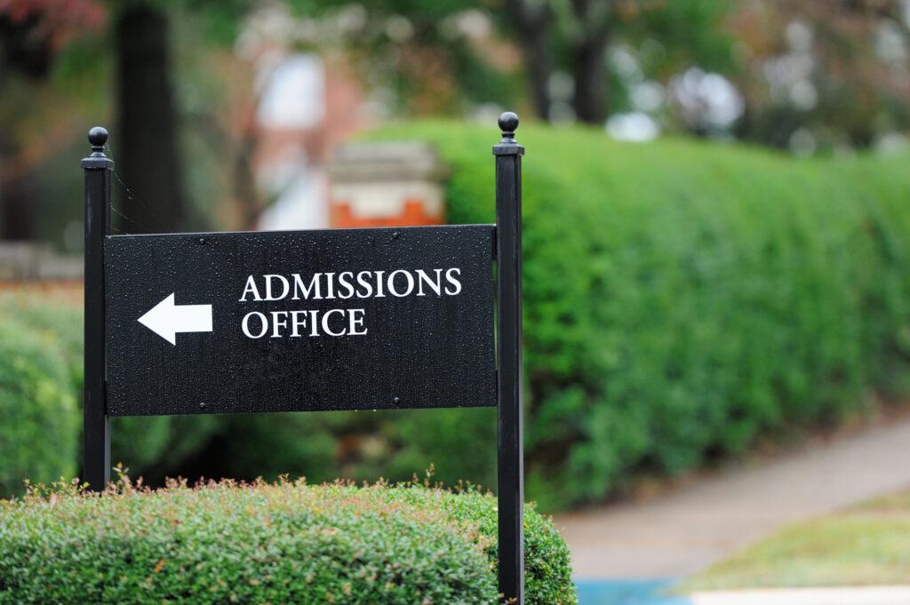 A black sign on a public university campus reads "Admissions Office." Here's how to prepare for a college admissions interview.