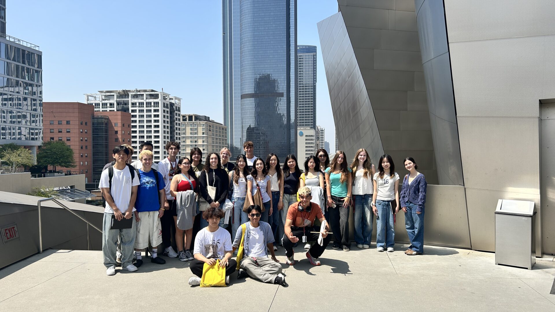 Students in the Exploration of Architecture summer program pose in a group on top of the Walt Disney Concert Hall, with the skyline of Los Angeles in the background.