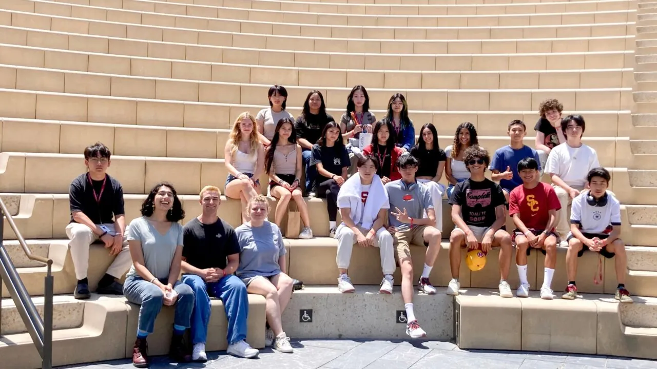 Group of students seated on tiered steps posing for a group photo.