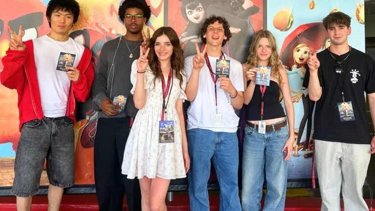 Students pose in front of life-size movie posters at Sony Pictures Studios.
